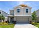 Charming two-story home featuring a two-car garage, landscaped front yard, and modern architectural details at 1764 Frogmore Ave, Haines City, FL 33844