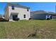 Grassy backyard featuring a patio area and partial view of neighboring houses at 1204 Berry Ln, Davenport, FL 33837