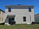 Backyard view of home featuring stucco exterior, small patio, and grill at 1204 Berry Ln, Davenport, FL 33837