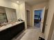 Bathroom featuring double sinks, granite countertops, and access to the main bedroom at 1204 Berry Ln, Davenport, FL 33837