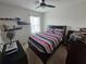 Comfortable bedroom with a ceiling fan, neutral colors, and shelving displaying collectible figurines at 1204 Berry Ln, Davenport, FL 33837