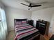 Comfortable bedroom with a ceiling fan, neutral colors, curtains, and dark-toned furniture at 1204 Berry Ln, Davenport, FL 33837