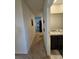A hallway with a carpet floor that leads to a bathroom on the right and other rooms straight ahead at 1204 Berry Ln, Davenport, FL 33837