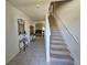 Inviting foyer featuring tile flooring, a staircase, and views into the living spaces at 1204 Berry Ln, Davenport, FL 33837
