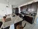 Modern kitchen featuring dark wood cabinets, granite countertops, and stainless steel appliances at 1204 Berry Ln, Davenport, FL 33837
