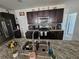 Granite kitchen island featuring a stainless steel sink, faucet, and dark wood cabinets at 1204 Berry Ln, Davenport, FL 33837