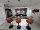 Modern kitchen island with granite countertop, stainless steel sink, and seating for three at 1204 Berry Ln, Davenport, FL 33837