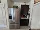 Convenient kitchenette featuring stainless steel refrigerator and dark wood cabinetry at 1204 Berry Ln, Davenport, FL 33837