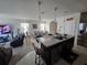 Open-concept living area with kitchen island, dining table, and comfortable seating arrangement at 1204 Berry Ln, Davenport, FL 33837