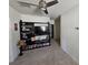 View of a modern living room with a ceiling fan, built-in shelving unit, and neutral carpeting at 1204 Berry Ln, Davenport, FL 33837