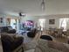 Spacious living room featuring neutral carpet, ceiling fan, dining area, and lots of windows at 1204 Berry Ln, Davenport, FL 33837