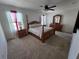 Spacious bedroom featuring a four-poster bed, ceiling fan, and a matching dresser with large mirror at 1204 Berry Ln, Davenport, FL 33837