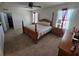 Spacious bedroom featuring a four-poster bed, ceiling fan, and access to a walk-in closet at 1204 Berry Ln, Davenport, FL 33837