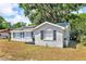 View of the well-maintained one-story home exterior with green lawns, landscaping and mature trees at 1480 E Davidson St, Bartow, FL 33830