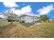 Rear exterior view of white home showing small patio area and tidy landscaping at 1610 Reynolds Rd # 353, Lakeland, FL 33801