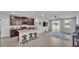 A kitchen area has dark wood cabinets, a granite counter top island with three stools, and stainless steel appliances at 1859 Carnostie Rd, Winter Haven, FL 33884