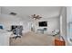 Spacious living room with carpet, ceiling fan, and natural light. Includes desk and television at 1859 Carnostie Rd, Winter Haven, FL 33884