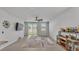 A living room includes a ceiling fan, tile floors, sliding glass doors to outside, and a bar cabinet at 1859 Carnostie Rd, Winter Haven, FL 33884