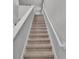 Carpeted stairway with white railing leading to the upper level at 1859 Carnostie Rd, Winter Haven, FL 33884