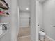 Spacious walk-in closet with shelving for storage and tiled floors leading to toilet at 1859 Carnostie Rd, Winter Haven, FL 33884