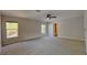 Generous main bedroom featuring neutral carpeting, a ceiling fan, and plenty of sunlight at 6918 Lake Eaglebrooke Dr, Lakeland, FL 33813