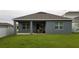 Backyard featuring a grey house with a covered patio at 753 Grand Hilltop Dr, Apopka, FL 32703
