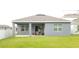 Backyard featuring a grey house with a covered patio at 753 Grand Hilltop Dr, Apopka, FL 32703