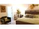 Inviting bedroom with wooden bed, a green chair, a plant, and an artwork at 753 Grand Hilltop Dr, Apopka, FL 32703