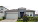 Charming single-story home featuring a two-car garage, and a neatly landscaped front yard at 753 Grand Hilltop Dr, Apopka, FL 32703