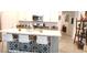 Kitchen island with seating, white countertop, tile accents, and views into the home at 753 Grand Hilltop Dr, Apopka, FL 32703