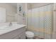 Bathroom with white vanity, decorative floral art, and a shower with a patterned curtain at 1646 Seth Dr, Winter Haven, FL 33880