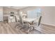 Modern dining room with a white table, chrome-legged chairs, wood flooring, and sliding glass doors at 1646 Seth Dr, Winter Haven, FL 33880