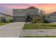 Charming two-story home with a well-manicured lawn, inviting entrance and neutral color scheme under a colorful sky at 1646 Seth Dr, Winter Haven, FL 33880