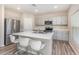 Modern kitchen features stainless steel appliances, stylish gray cabinets, a quartz countertop island, and barstool seating at 1646 Seth Dr, Winter Haven, FL 33880