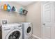 Laundry room with modern washer and dryer units and shelving for storage at 1646 Seth Dr, Winter Haven, FL 33880