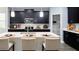 Modern kitchen with black cabinets, stainless steel appliances, and a large island with seating at 1863 Clear Sky Dr, Kissimmee, FL 34744
