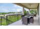 Covered balcony featuring wicker chairs, a ceiling fan, and scenic backyard views, perfect for outdoor dining at 1911 Clear Sky Dr, Kissimmee, FL 34744