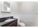 Bathroom with vanity, white sink, black countertop, medicine cabinet, and toilet at 222 Aldo Dr, Babson Park, FL 33827