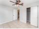 Bright bedroom featuring neutral walls, tile floors, ceiling fan, closet, and access to an en suite bathroom at 222 Aldo Dr, Babson Park, FL 33827