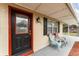 Close-up of the front door and sitting area on the covered porch of the home at 222 Aldo Dr, Babson Park, FL 33827