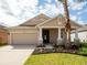 Charming single-story home with a two-car garage, manicured lawn, and a welcoming front porch with elegant columns at 2457 Torrens Dr, Lakeland, FL 33805