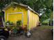 A backyard with a yellow storage shed, grill and propane tank, and gardening supplies at 730 Citrus St, Orlando, FL 32805