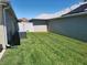 Lush backyard features a manicured lawn and a modern AC unit at 6030 Dijulio Ter, The Villages, FL 32163