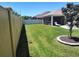 Spacious backyard with a well-manicured lawn and mature tree landscaping at 6030 Dijulio Ter, The Villages, FL 32163