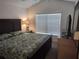 Bedroom featuring a large bed, side table, and dresser with a TV at 6030 Dijulio Ter, The Villages, FL 32163