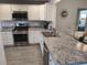 Updated kitchen featuring stainless steel appliances, granite countertops, and gray backsplash at 6030 Dijulio Ter, The Villages, FL 32163