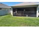 Screened-in lanai with outdoor seating and a view of the green backyard at 6030 Dijulio Ter, The Villages, FL 32163