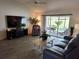 Comfortable living room with sliding glass doors, modern furniture, and wood-look flooring at 6030 Dijulio Ter, The Villages, FL 32163