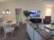 Open-concept living space with modern light fixture and entertainment center at 6030 Dijulio Ter, The Villages, FL 32163