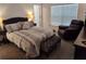 Cozy main bedroom features a plush bed, soft lighting, and a comfortable reading chair at 6030 Dijulio Ter, The Villages, FL 32163